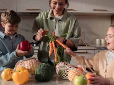 A family enjoys quality time in the kitchen, preparing a meal with fresh vegetables.