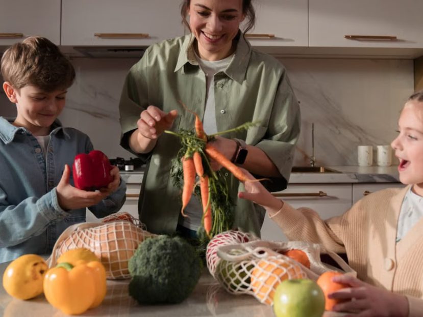 A family enjoys quality time in the kitchen, preparing a meal with fresh vegetables.